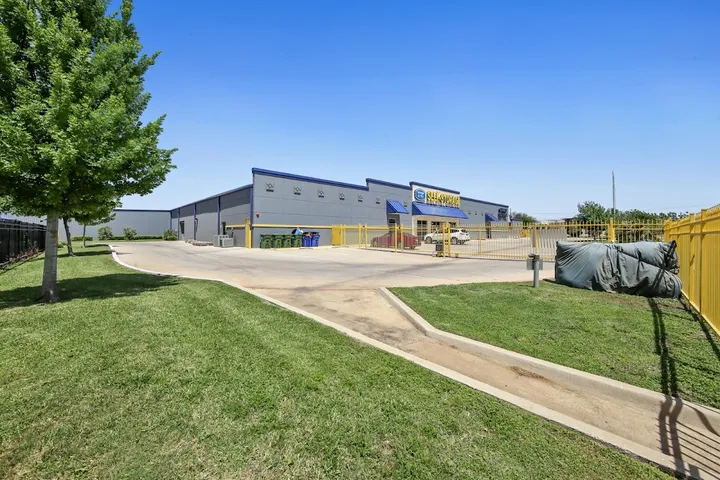 Exterior view of storage facility with fence and security gate.