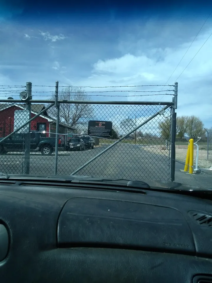 View from a car of the facility gate and security fence.