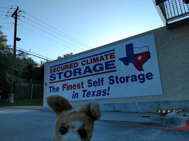 Large sign on building exterior 'Secured Climate Storage, The Finest Self Storage in Texas'.