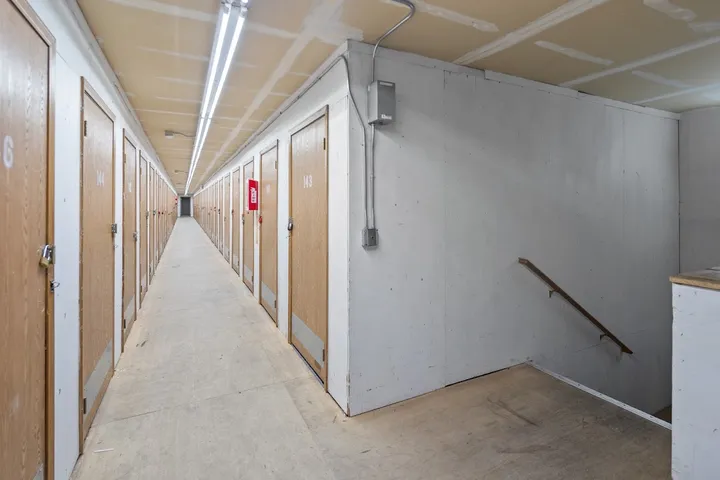 Long hallway with many wooden storage unit doors.