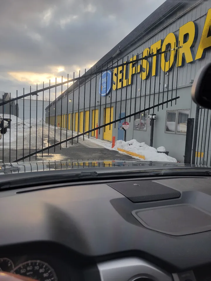 View of facility entrance gate and exterior building from inside a car.