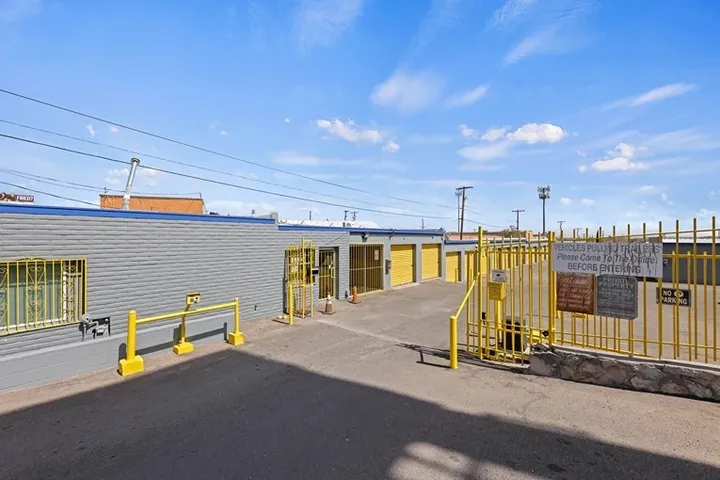 Outdoor view of facility entrance with yellow gate and signage.