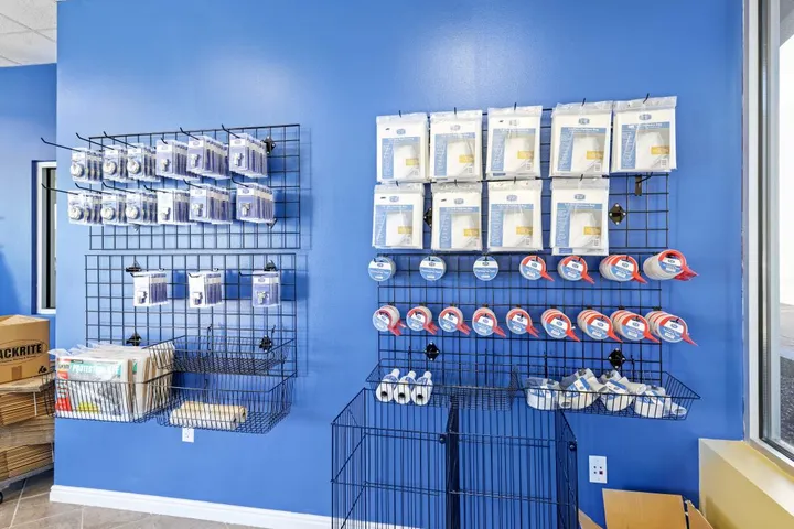 Various packing and moving supplies hanging on a blue wall in the office.