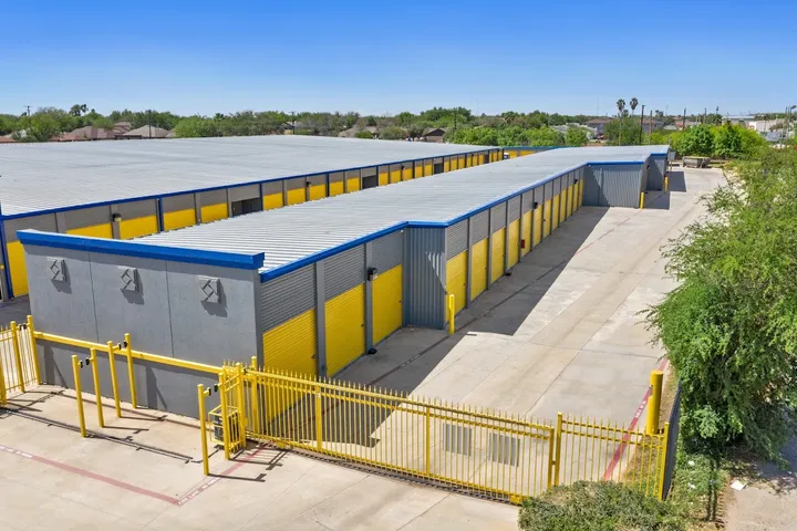 Aerial view of yellow roll-up door storage units with security gates.