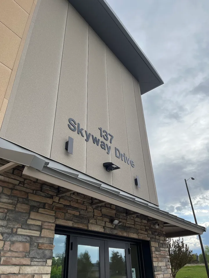 Building corner with address '137 Skyway Drive' on light gray facade.