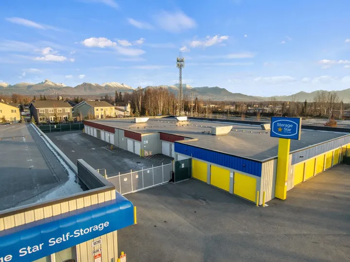 Aerial view of self-storage facility with signage and distant mountains.