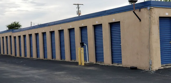 Exterior of a storage building with blue roll-up doors.