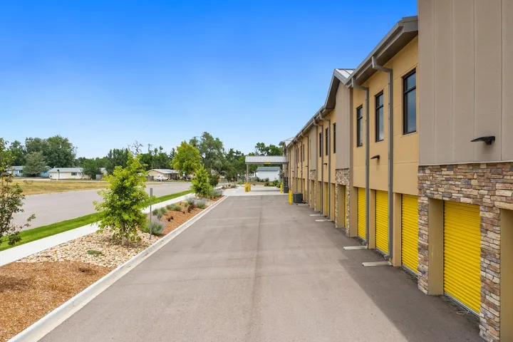 Exterior view of storage units with yellow doors and drive-up access.