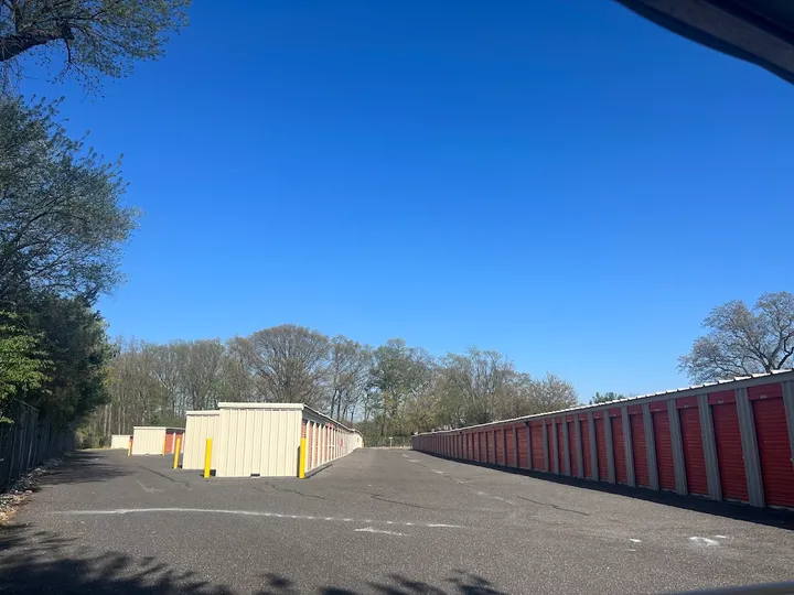 Outdoor storage units with a fence alongside.