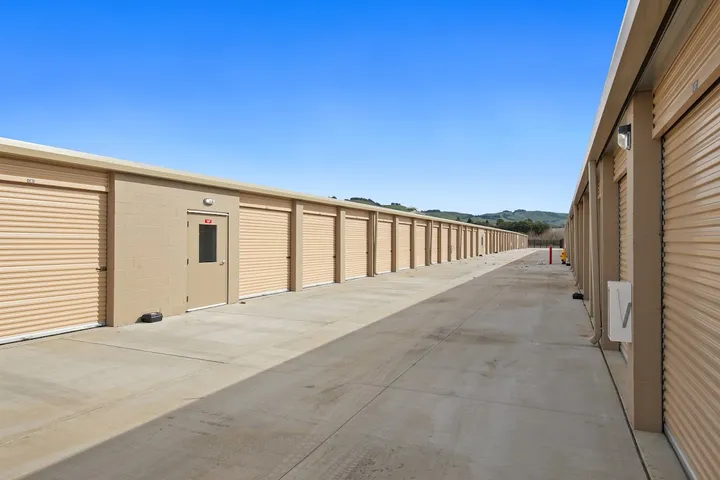 Rows of outdoor storage units with roll-up doors.