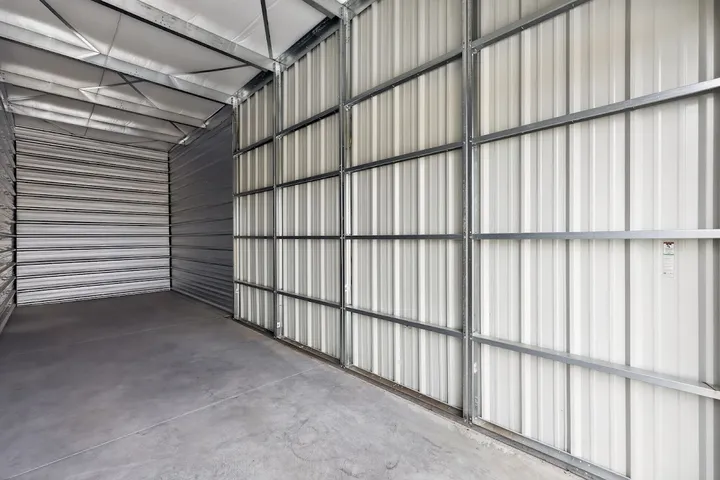 Interior of an empty storage unit with corrugated metal walls.