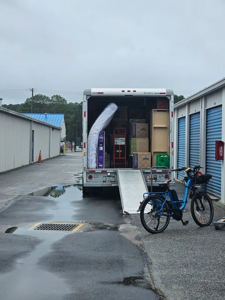 Moving truck loaded with belongings backed up to storage unit.