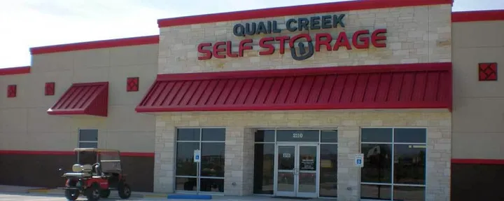 Quail Creek Self Storage storefront with red signage.