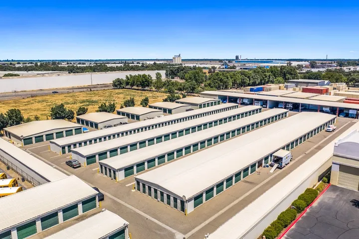 Aerial view of multiple rows of outdoor storage units with green doors.