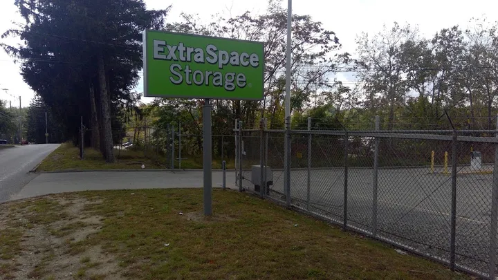 Extra Space Storage outdoor sign at entrance with chain link fence.