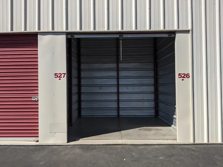 Open storage unit door with unit numbers visible.