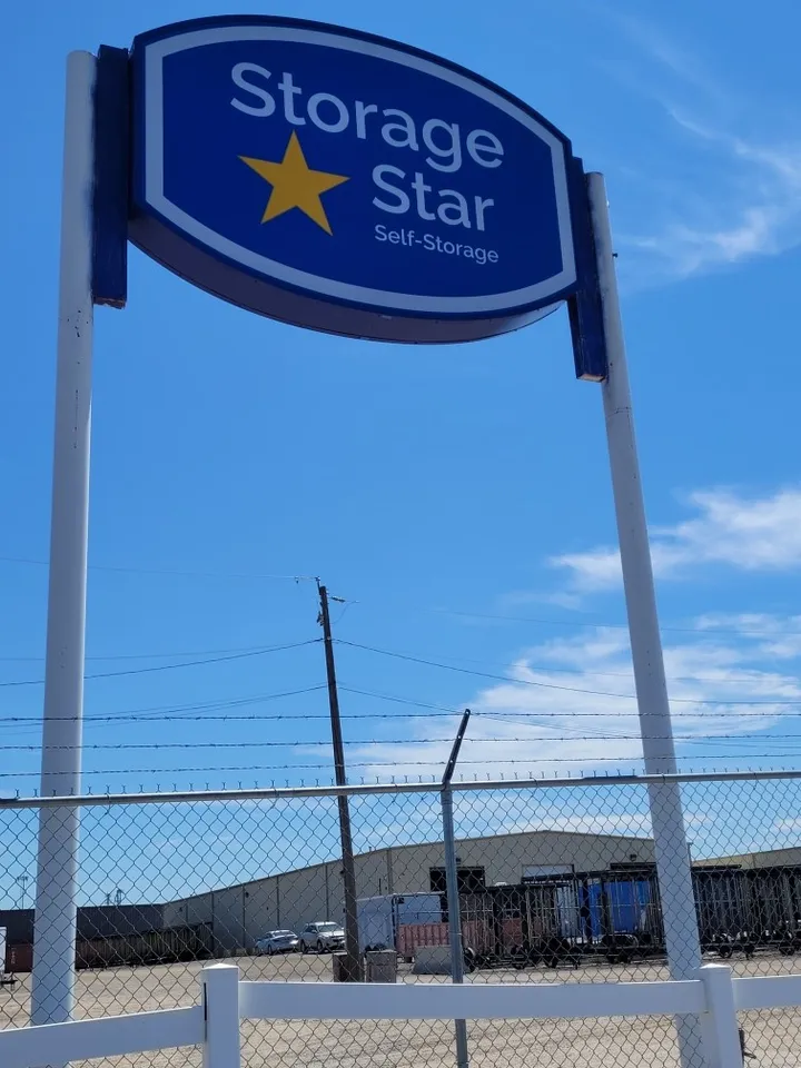 Storage Star monument sign by a chain-link fence.