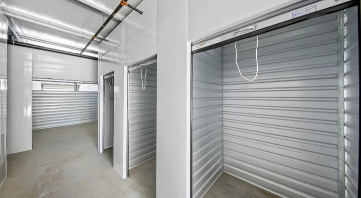 Open indoor storage unit doors showing corrugated metal walls.