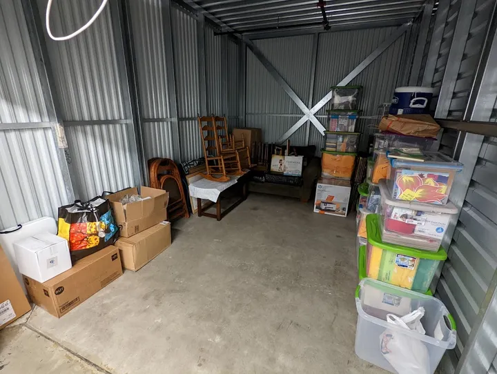 Interior of a storage unit with boxes and furniture.