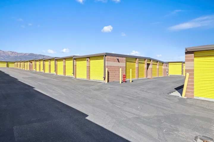 Outdoor drive-up storage units with yellow doors.