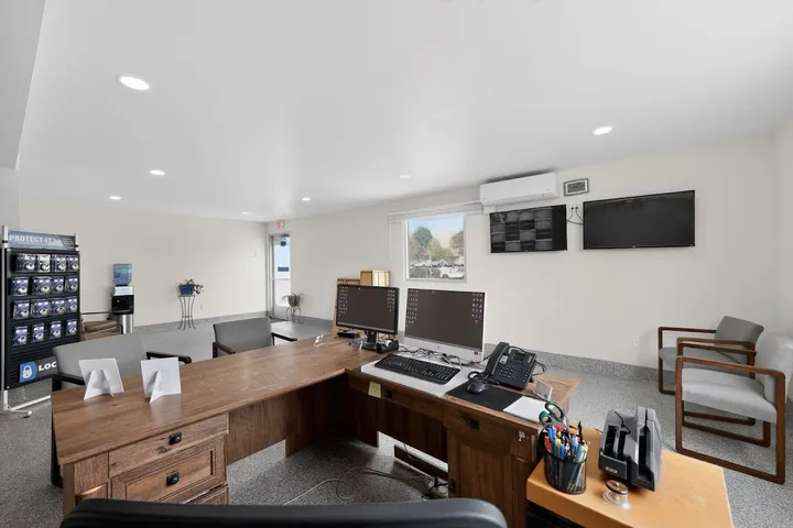 Office interior with front desk, security monitors, and packing supplies display.