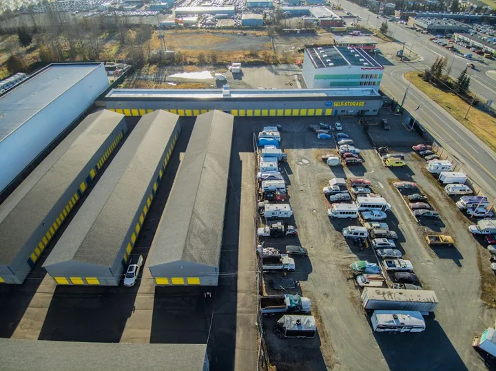 Aerial view of self-storage facility with buildings and outdoor vehicle parking.