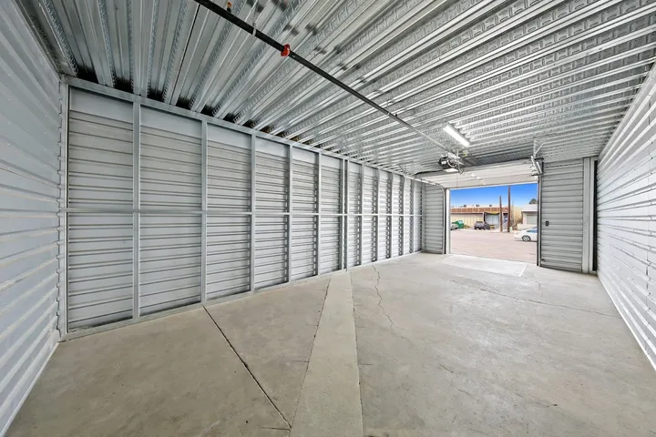 Empty drive-up storage unit with open door and metal walls