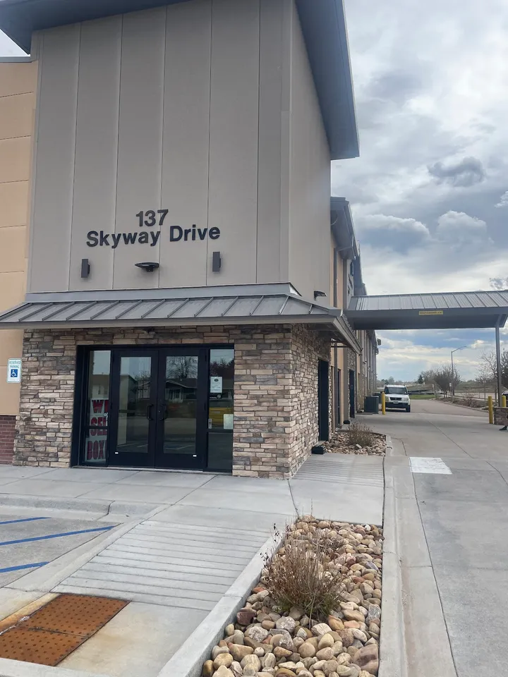Building entrance with address sign '137 Skyway Drive'.