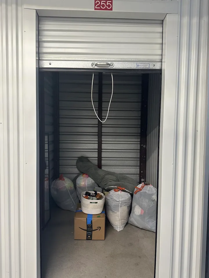 Inside a storage unit filled with bags and boxes.