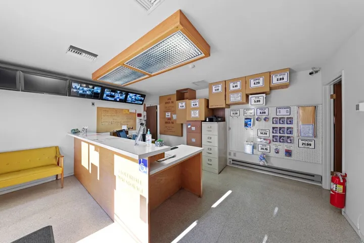Interior of office with front desk, security monitors, and boxes