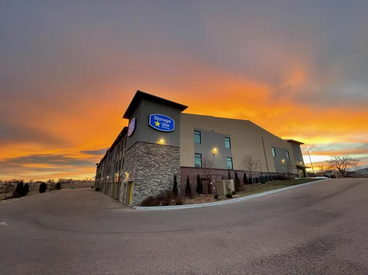 Storage facility exterior at sunset with warm orange sky.