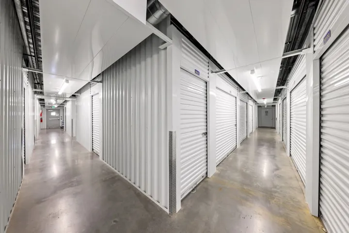 Indoor climate-controlled storage hallway with white unit doors.