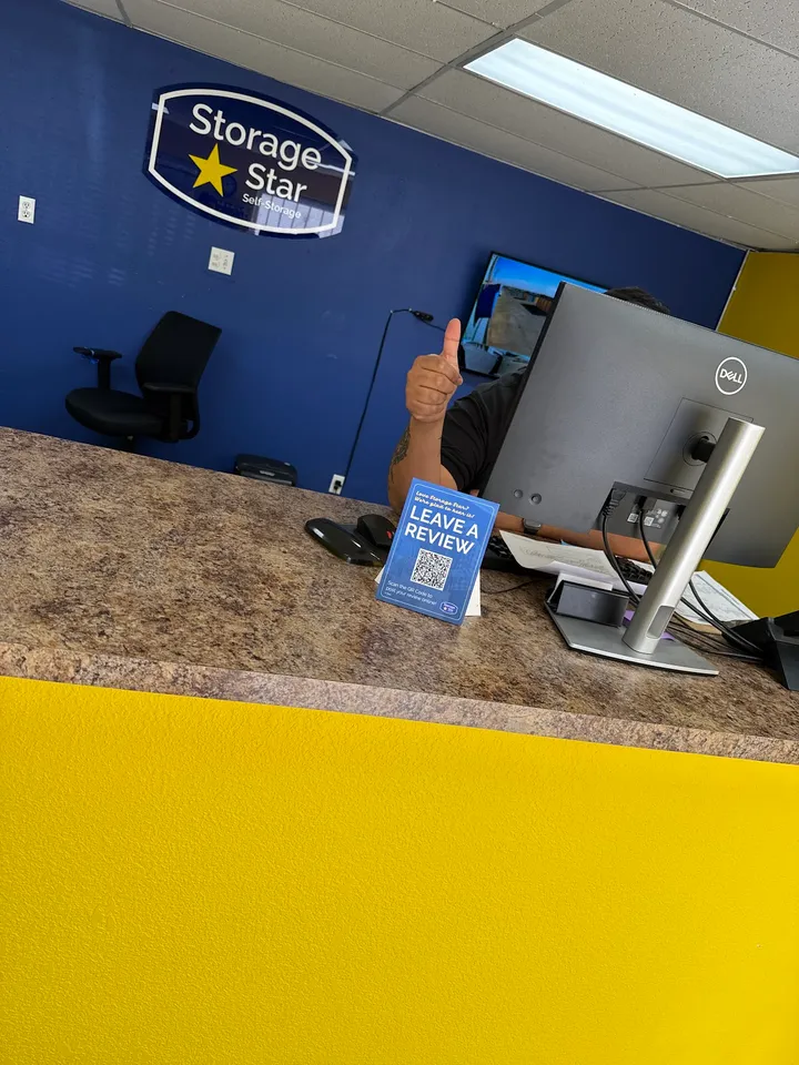 Person working at a desk in the office, giving a thumbs up.