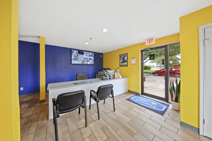 Customer service office with desk, chairs, and security monitor.