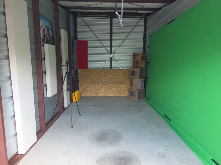 Interior of a storage unit with exposed metal walls and concrete floor.