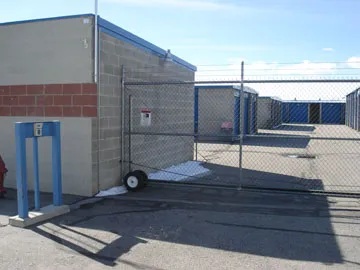 Security gate and chain-link fence at storage facility entrance.