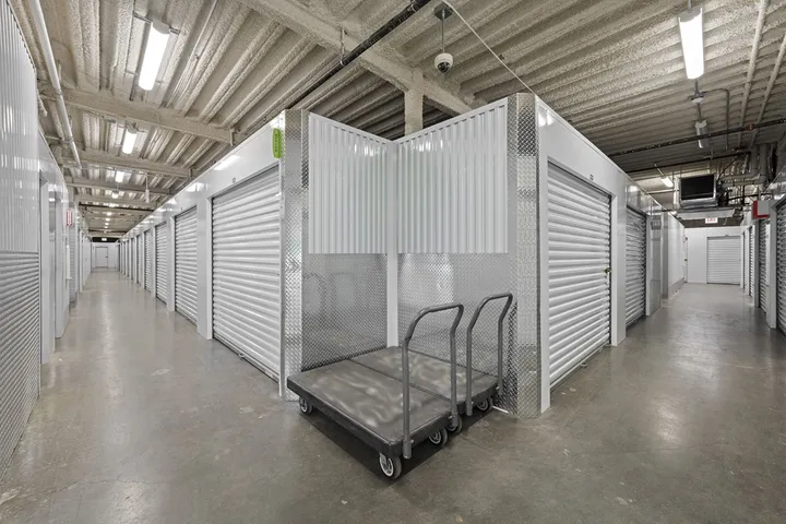 Indoor hallway with rows of storage units and a moving cart