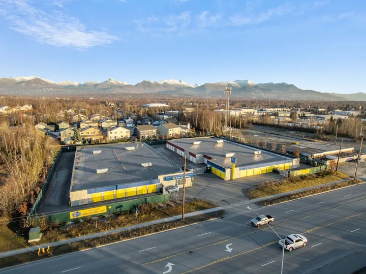 Aerial view of storage facility with parking lot and mountains in background.
