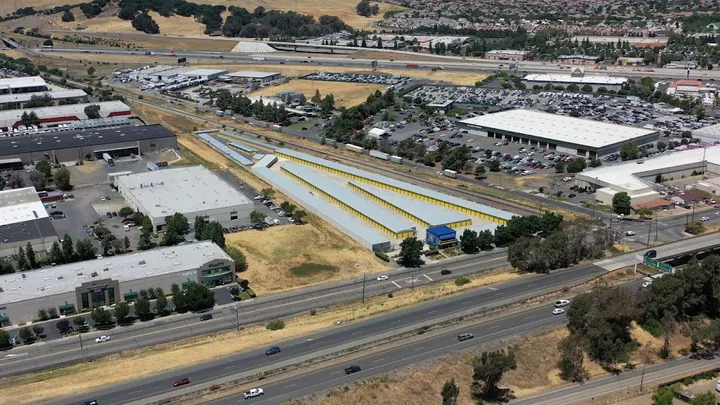 Aerial view of storage facility and surrounding area with highway.