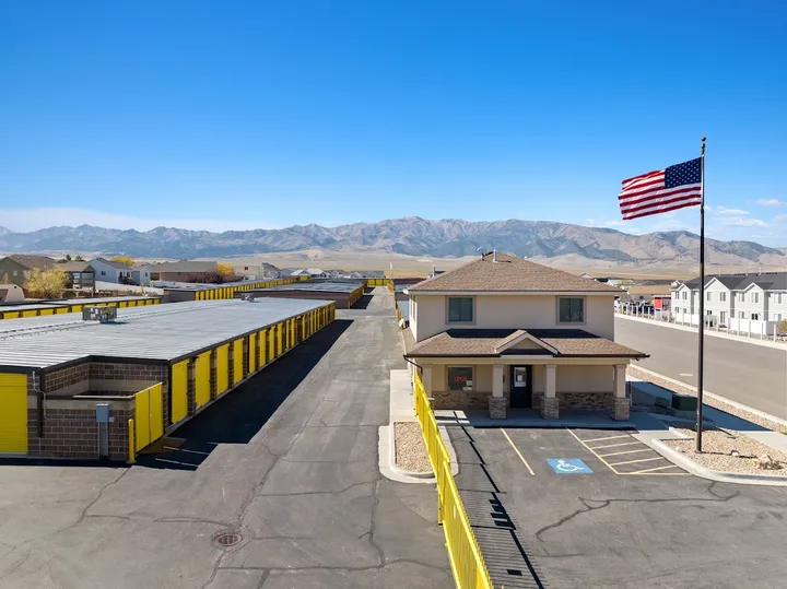 Overview of storage facility office building and units with American flag.