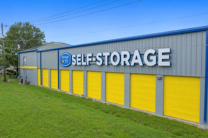 Exterior of storage building with yellow doors and blue signage.