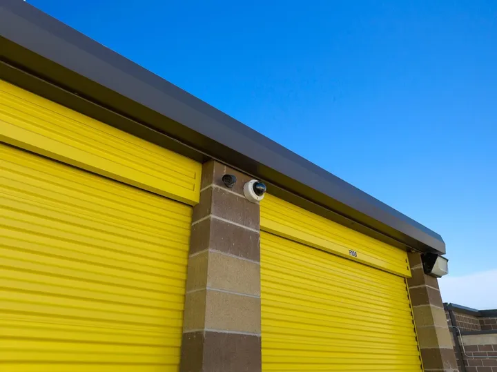 Exterior of storage units with security camera visible.