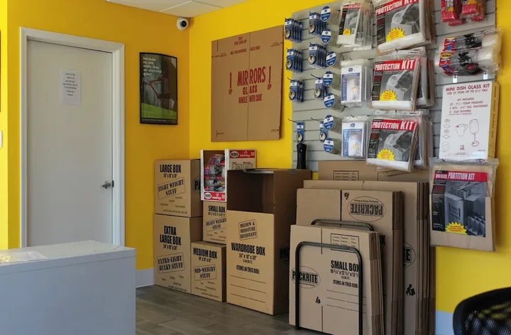 Office interior with packing supplies for sale, including boxes and tape.