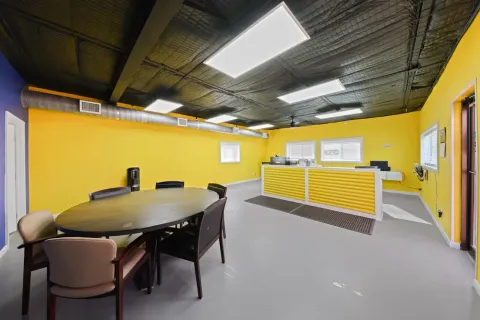 Inside the self-storage facility office at Storage Star on N O'Connor Rd with yellow walls, a gray floor, a yellow desk, and a round table with chairs