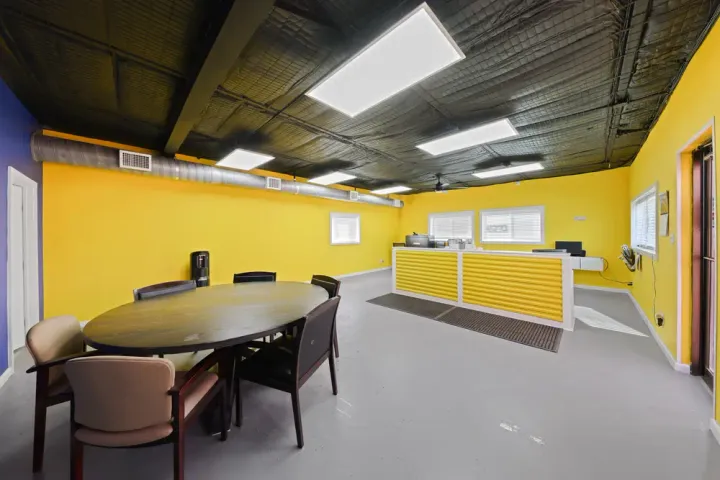 Inside the self-storage facility office at Storage Star on N O'Connor Rd with yellow walls, a gray floor, a yellow desk, and a round table with chairs