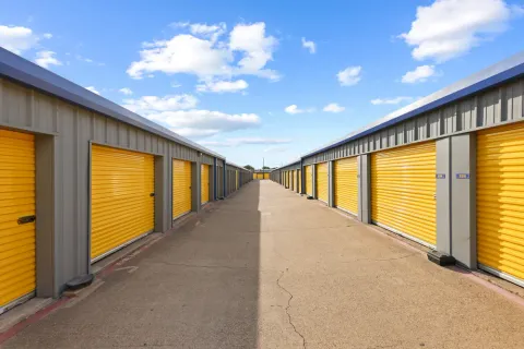 Row of drive-up storage units in Irving, TX, on N O'Connor Rd with secure yellow roll-up doors for easy access