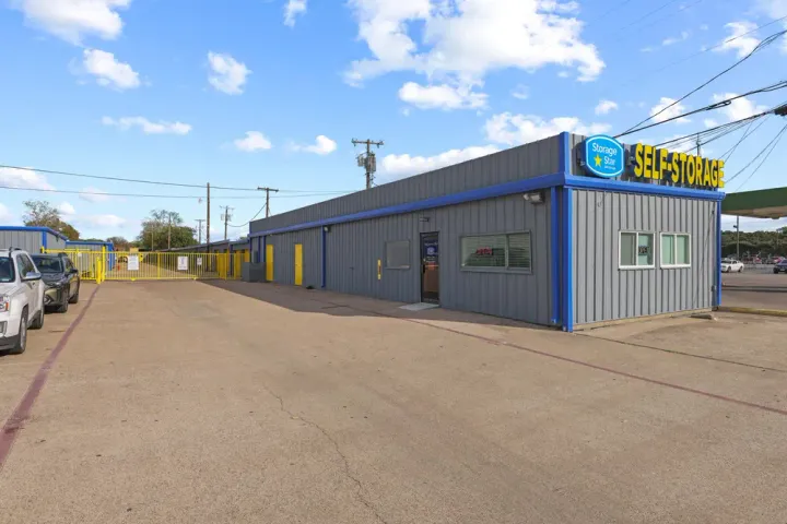 Gray office building at Storage Star Self-Storage in Irving on N O'Connor Rd, with Storage Star signage next to a yellow gated entranceway