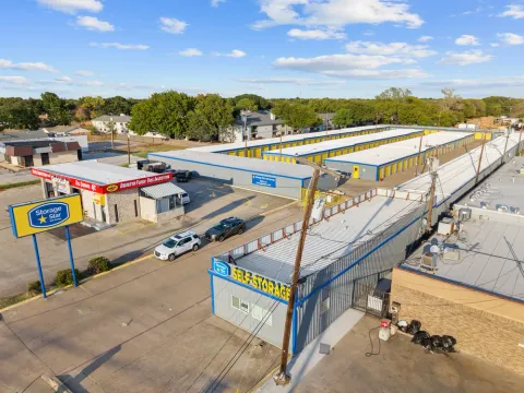 Aerial view of drive-up self-storage buildings at Storage Star in Irving, TX, with yellow roll-up doors and gray metal roofs