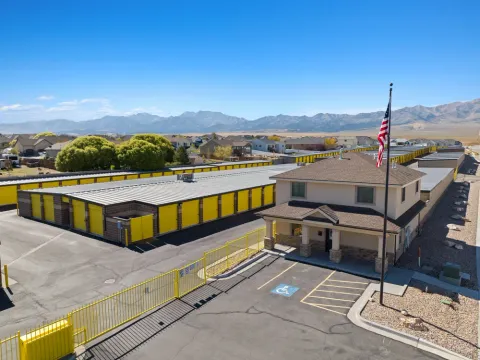 Aerial view of Storage Star Grantsville office and rows of units with yellow doors and mountains behind