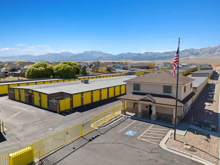 Aerial view of Storage Star Grantsville office and rows of units with yellow doors and mountains behind